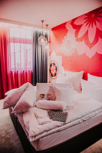a bedroom with a large bed with pink flowers on the wall at Hotel & Restaurant Heyligenstaedt in Gießen
