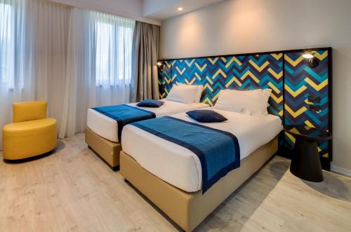 a hotel room with two beds and a chair at Best Western Hotel Cristallo in Rovigo