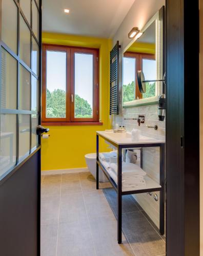 a bathroom with yellow walls and a sink and a tub at Best Western Hotel Cristallo in Rovigo
