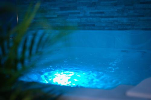 una piscina por la noche con una luz azul en Nuit vip spa sauna privatif, en Le Rove