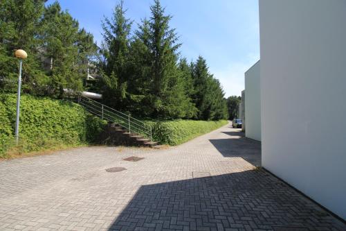 a brick walkway with a white building and trees at Golf Course - Luxurious Flat T3 - Ponte de Lima in Ponte de Lima