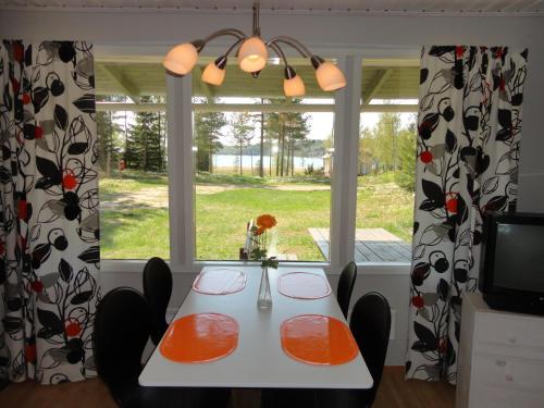 comedor con mesa y sillas frente a una ventana en Hjortö Stugor & Stockhus en Ödkarby