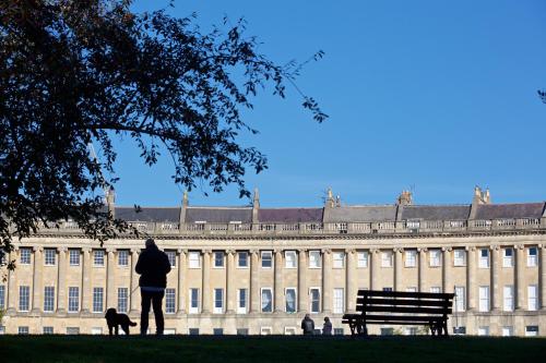 a person walking a dog in front of a building at The Z Hotel Bath in Bath