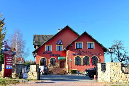 a large red building with a sign in front of it at Zajazd Zagłoba in Widoma