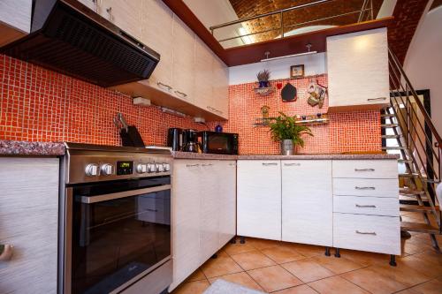 a kitchen with white cabinets and a brick wall at OLD SQUARE APARTMENTS 3 in Timişoara
