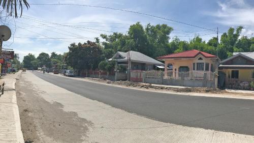 an empty street with houses on the side of the road at Hanella's Place in Bacong