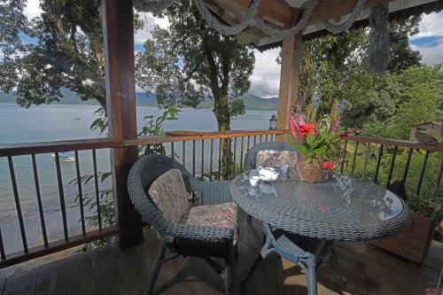 a table and chairs on a porch with a view of the water at Ecolodge el Arca Bahia Solano in Bahía Solano