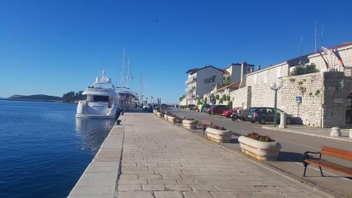 a boat is docked in a canal next to a street at Apartment Lavanda garden in Rab