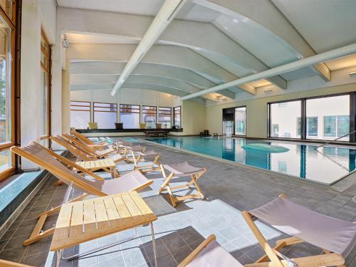 a pool with lounge chairs and a swimming pool at Schweizerhof Ferienwohnungen Lenzerheide 1 in Lenzerheide