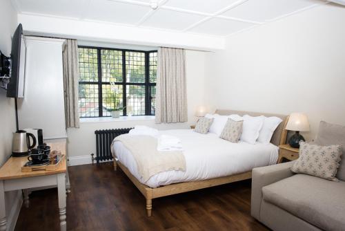 a bedroom with a bed and a couch and a window at The Fox in Winchester