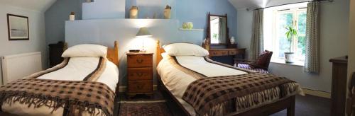 ペンブロークにあるWood Cottage, Stackpole Estate - NTのベッドルーム1室(ベッド2台、ドレッサー、窓付)