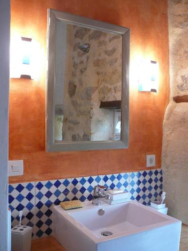 une salle de bain avec un lavabo et un miroir dans l'établissement La Ferme de Kerhors, à Tréméoc