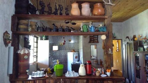 a kitchen with a counter with lots of items on it at Pousada Paineira in São Gonçalo do Rio das Pedras