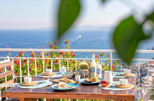 a table with plates of food and drinks on it at Paradise Relais Villa Janto' in Ischia