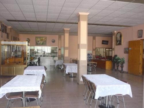 a room with white tables and chairs and a kitchen at Hotel Primavera in San Juan de los Lagos