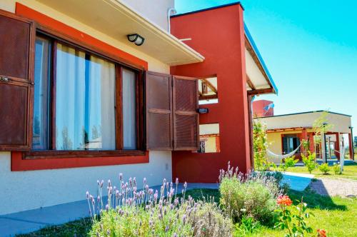 Casa con ventanas y paredes de color rojo y blanco en Cabañas Morita Mia en San Rafael