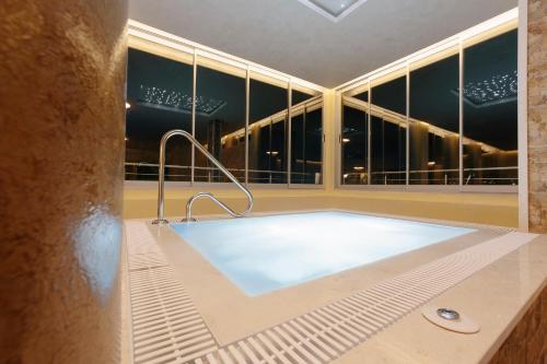 a large bath tub in a room with a window at Spa&Hotel Studenac in Trebinje