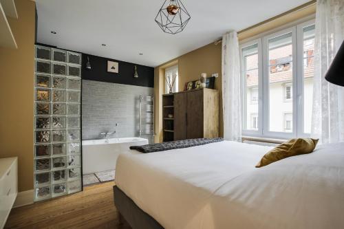- une chambre avec un grand lit et une baignoire dans l'établissement Le Leblois - 2 sdb Grande cuisine, à Strasbourg