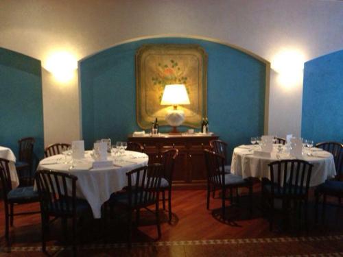 a dining room with tables and chairs and a lamp at Hotel Europa in Padova