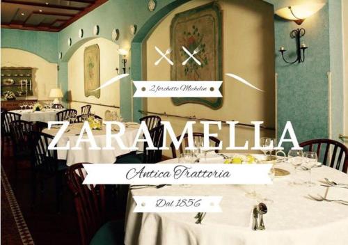 a restaurant with tables with white table cloth and a clock at Hotel Europa in Padova