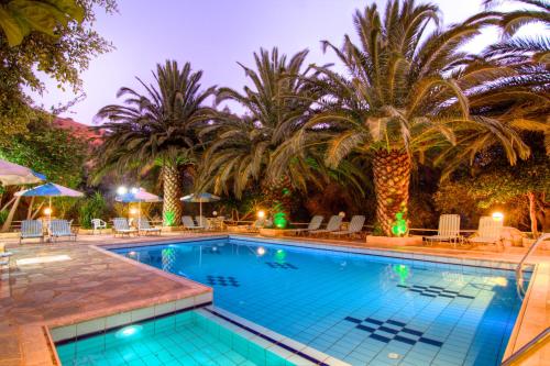 einen Pool mit Palmen in einem Resort in der Unterkunft Sunrise Hotel & Apartments in Rodakino