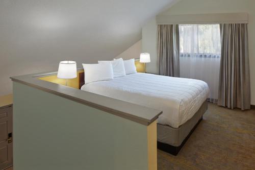 um quarto de hotel com uma cama e uma janela em New Haven Village Suites em New Haven