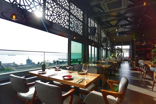 a restaurant with tables and chairs and a large window at Wes Hotel in Kocaeli