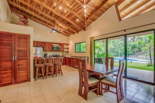 a kitchen with a wooden dining table and chairs at Hidden Palms in Nosara