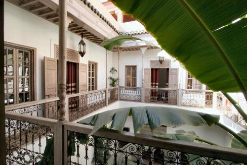 un balcón con mesa y sillas. en Riad Altair, en Marrakech