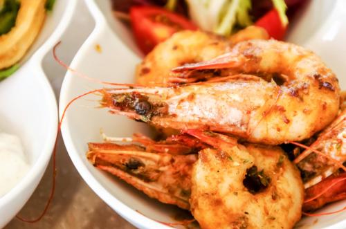 a plate of shrimp and vegetables on a table at 4reasons hotel + bistro | 12+ in Yalıkavak