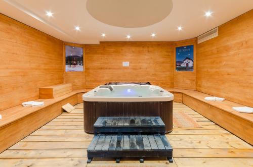 a jacuzzi tub in a room with wooden walls at Hotel Kelep in Tokaj