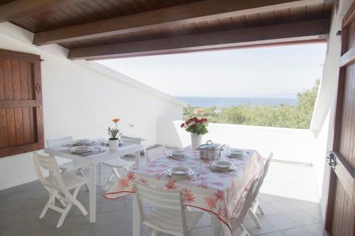 Un comedor con mesa y sillas y una ventana. en Ulivo, en Quartu SantʼElena