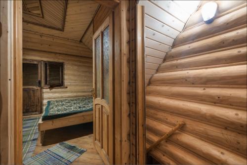um chalé de madeira com uma cama num quarto em Kotedzh Smereka em Kelechin