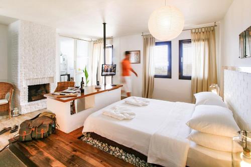 a bedroom with a white bed and a fireplace at 4reasons hotel + bistro | 12+ in Yalıkavak