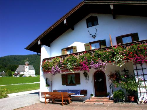 a white house with flowers on the side of it at Haus Wiesenrand in Berchtesgaden