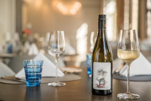 a bottle of wine sitting on a table with two glasses at Hotel & Restaurant Heyligenstaedt in Gießen