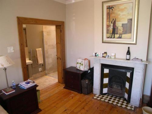 a living room with a fireplace and a mirror at Werner Guest Room in Cape Town