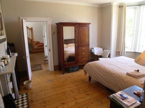 a bedroom with a bed and a dresser and a mirror at Werner Guest Room in Cape Town