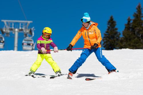 a man and a child on skis in the snow at Hotel U Kabinky in Janske Lazne