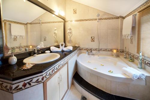 a bathroom with a large tub and a large mirror at Madalena's Apartment in Razáta