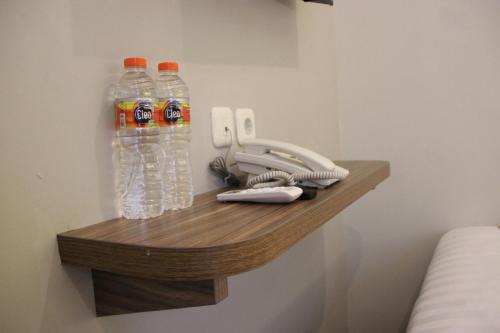 a shelf with two bottles of soda and a telephone at Front One Cabin Malioboro Jogja in Yogyakarta
