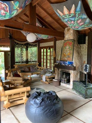 a large living room with a stone fireplace in a house at Pousada Santuário da Madre in Guarda do Embaú