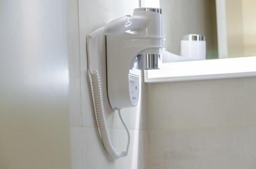 a phone is hanging on a wall in a bathroom at Ver Belém Suites in Lisbon