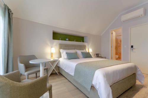 a bedroom with a bed and a table and chairs at Ver Belém Suites in Lisbon