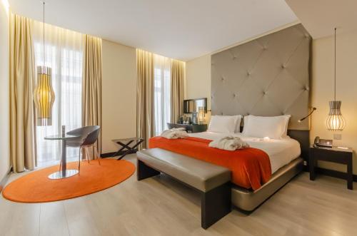 um quarto com uma cama grande e um cobertor vermelho em Hotel Santa Justa em Lisboa