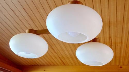 four white lights hanging from a ceiling at Smart House Oceanview in Ito