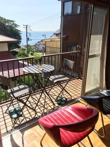a balcony with a table and chairs on a balcony at Smart House Oceanview in Ito