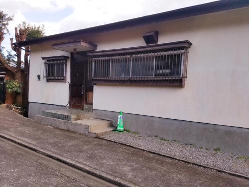 a house with a green fire hydrant in front of it at Smart House Oceanview in Ito