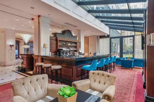 a lobby with a bar with blue chairs at Eurostars Danube Budapest in Budapest