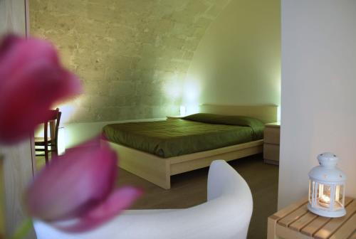 1 dormitorio con 1 cama y una flor rosa en Casa Natalì, en Matera